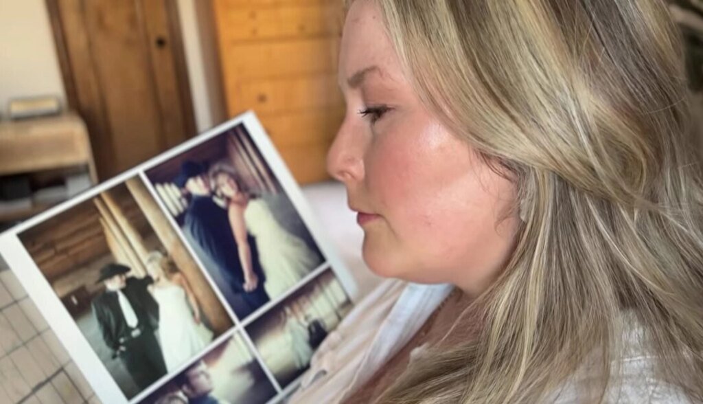 Woman looking at wedding photos while reflecting on loneliness in marriage