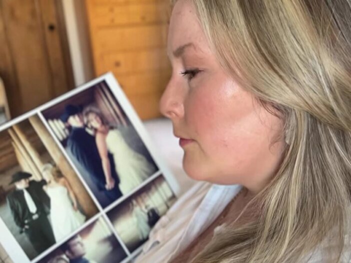 Woman looking at wedding photos while reflecting on loneliness in marriage